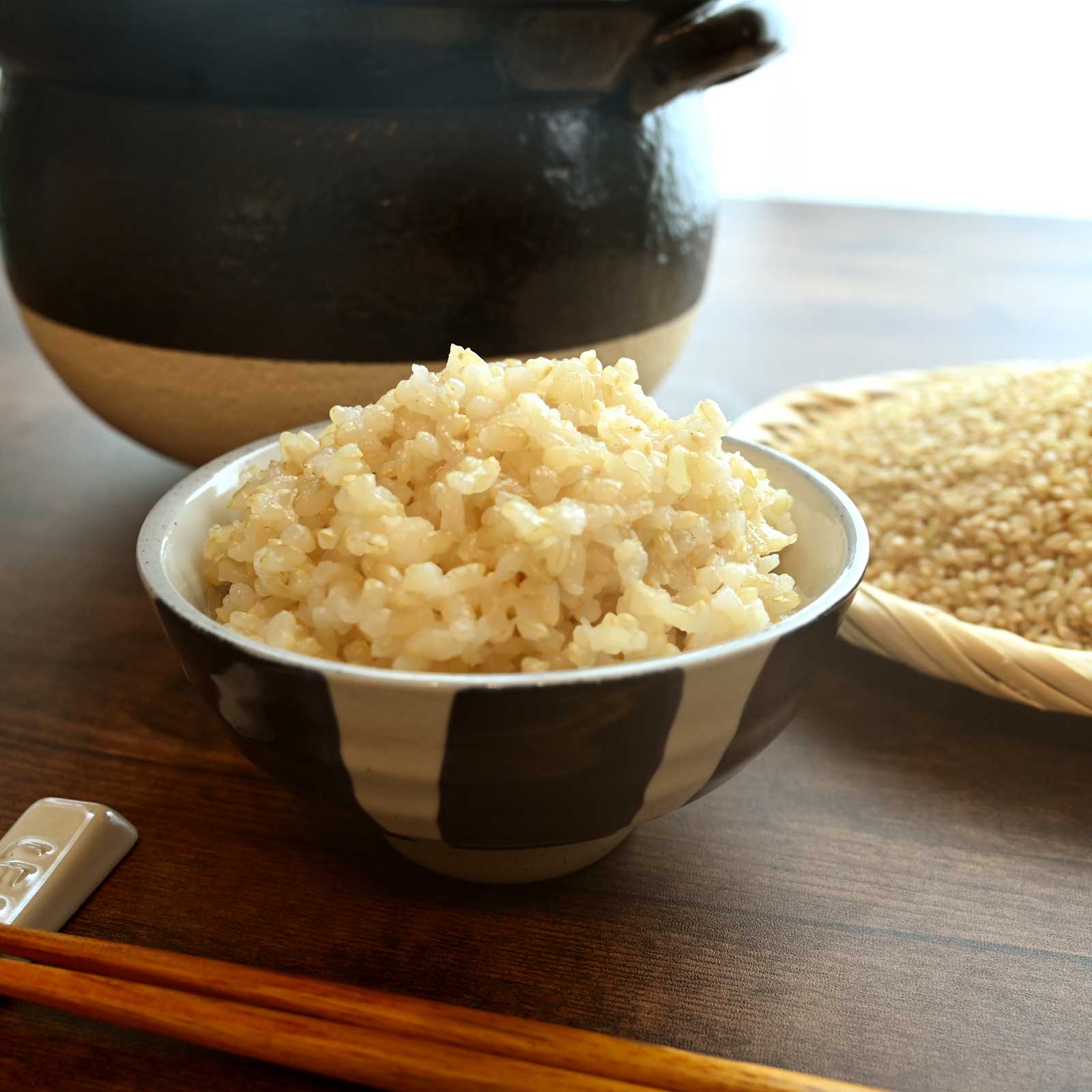 お茶碗に盛られた玄米ごはんと箸と土鍋