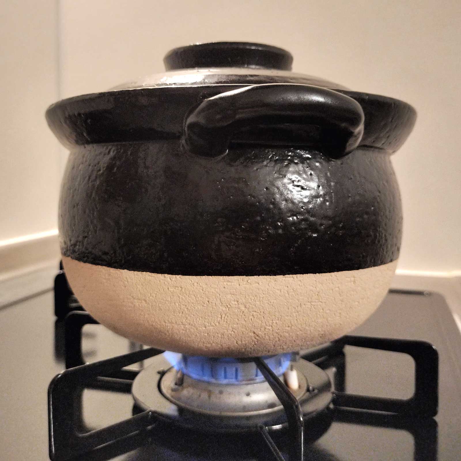 土鍋を火にかけて炊く様子